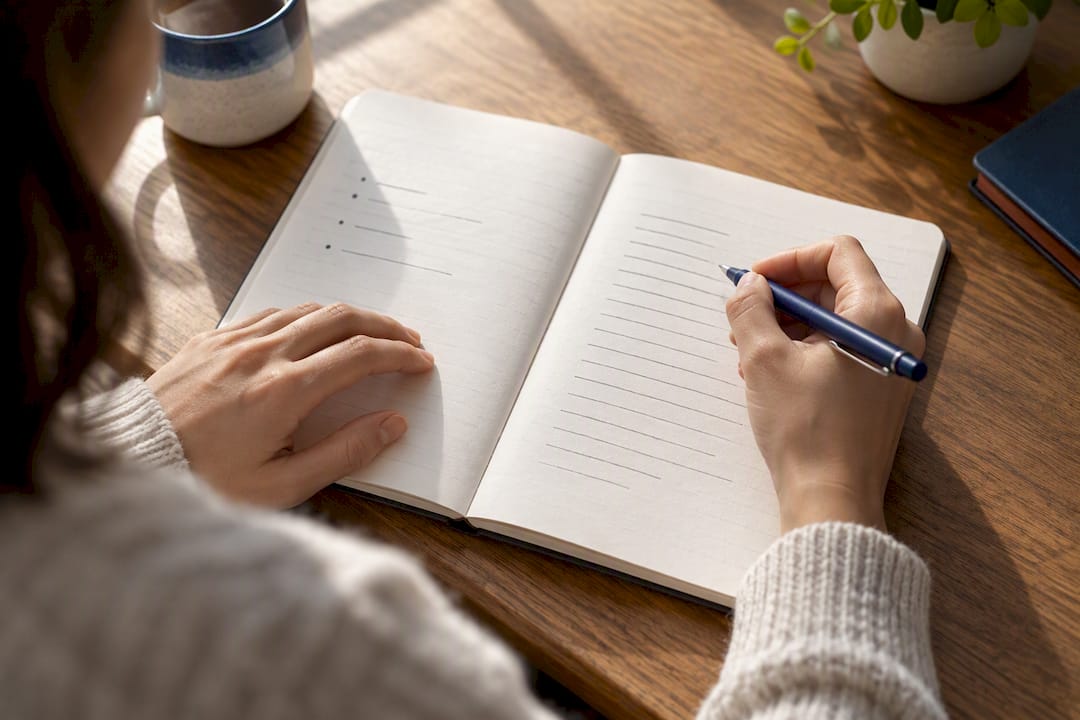 Hands comparing journal writing formats