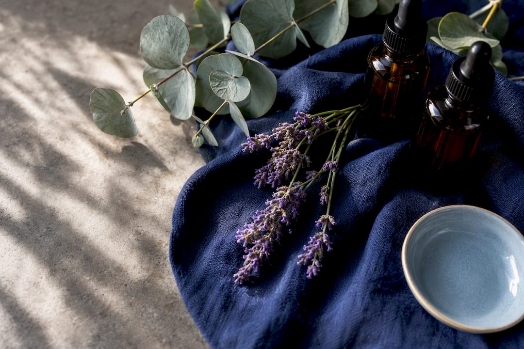 Lavender and eucalyptus botanicals beside oil bottles