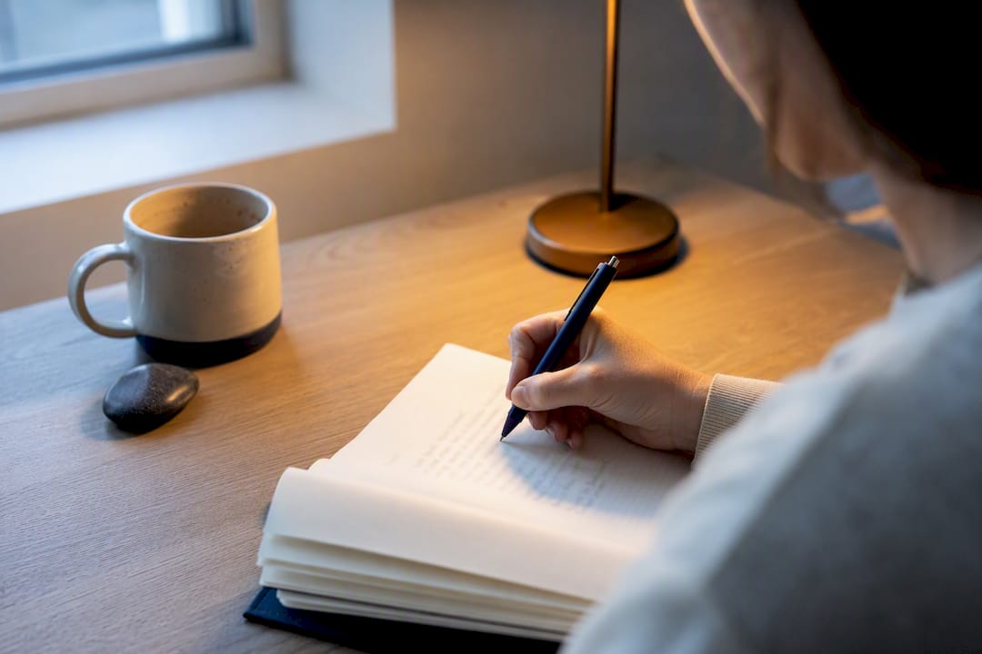 Hand writing a self-reflection journal entry